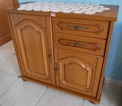 une armoire en bois surmontée d'un napperon blanc