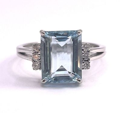 a close up of a ring with an aquamarine stone and diamonds
