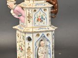 a figurine of a woman and a monkey on top of a clock tower