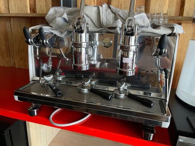 une machine à café posée sur un plan de travail rouge