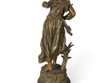 bronze statue of a woman with a bird on her shoulder