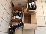 Des cartons de vin sont alignés sur le carrelage d'une cuisine