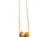 gros plan d'un collier en or sur une surface blanche