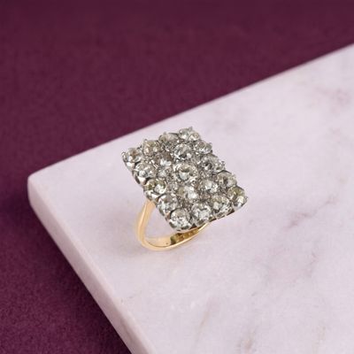 une photo d'une bague sertie de plusieurs diamants posée sur une surface en marbre