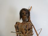 une statue en bois représentant une femme tenant un bâton à la main
