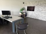 un bureau avec un ordinateur et une chaise dans une pièce