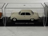 three model cars are in a display case on a white surface