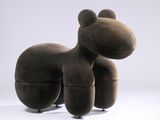 un grand objet en forme de chien brun posé sur une surface blanche