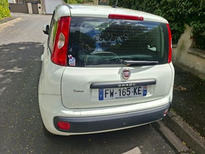 une petite voiture blanche garée sur le bord de la route