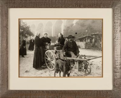 a black and white photo of a group of people and a dog