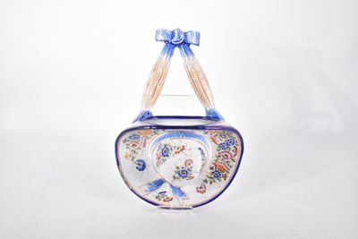 une petite horloge bleue et blanche ornée d'un nœud