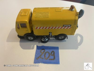 un petit camion jaune en plastique posé sur une table