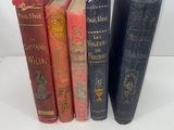 four books are lined up in a row on a white surface