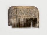 un peigne marron orné d'un motif sur un fond blanc