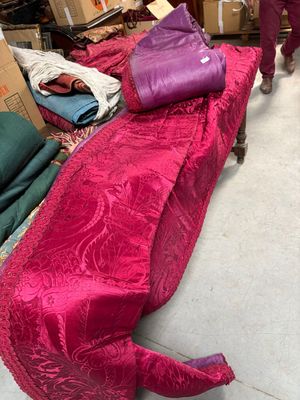 une femme debout à côté d'un canapé recouvert d'un tissu rose