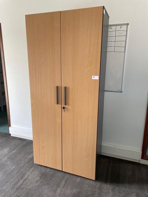 a tall wooden cabinet in the corner of a room