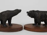 pair of black bears on wooden bases on a white background
