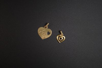 deux breloques en forme de cœur dorées sur un fond noir