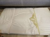 a white sheet with a gold design on it on a wooden floor