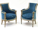 une paire de fauteuils en velours bleu, avec des bordures dorées et des pieds en bois