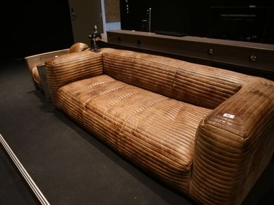 un canapé en cuir marron exposé dans une pièce