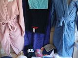 Plusieurs serviettes et peignoirs sont exposés dans une salle de bains