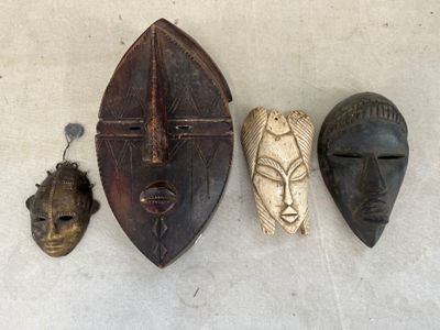 trois masques en bois accrochés au mur les uns à côté des autres