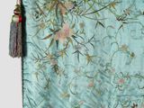 a blue and green tapestry hanging on a wall