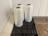 two rolls of plastic are sitting on a pallet in a room