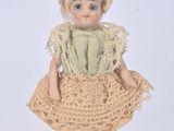 a small doll that is wearing a dress and a hat