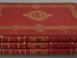 four red books stacked on top of each other on a table