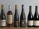 plusieurs bouteilles de vin sont alignées sur une table en bois