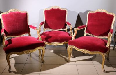 three red chairs with gold trim are sitting on a tiled floor