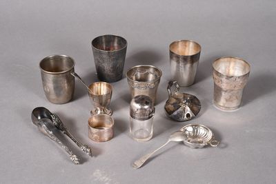 a lot of silver cups and spoons sitting on a table