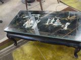 une table avec un plateau en verre sur lequel est représentée une image de chevaux