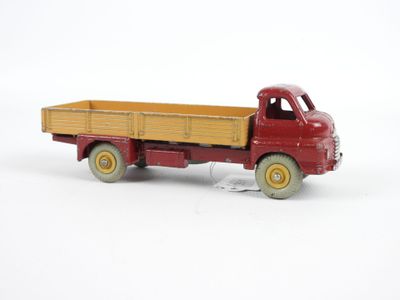 un camion jouet rouge avec une remorque en bois à l'arrière
