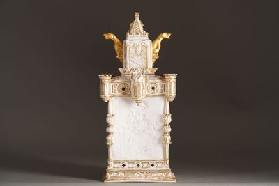 a white and gold clock on a stand with a black background