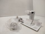 a white toilet with a toilet paper and a cup on it