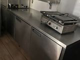 stainless steel counter top in a commercial kitchen with a stove and oven