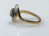an image of a gold and diamond ring on a white surface