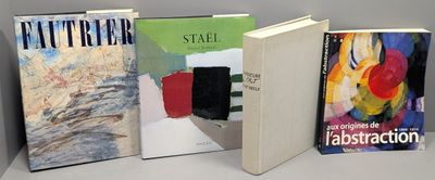 Quatre livres sont alignés sur une étagère devant un mur gris.