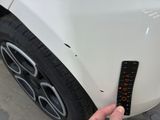 someone is measuring the height of a car ' s tire with a ruler