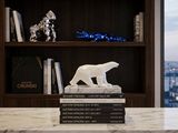 a white polar bear statue on top of a book shelf