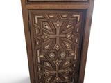 une image représentant une armoire en bois dont la porte est ornée d'un motif décoratif