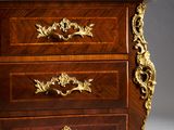 a wooden chest of drawers with a marble top