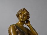 a bronze statue of a woman talking on a cell phone