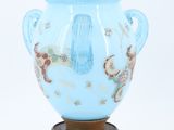 a blue vase that is sitting on a wooden stand