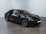 the black tesla model 3 is parked in a white room
