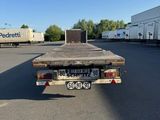 a flatbed truck that is parked in a parking lot
