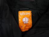a close up of a black jacket with an orange label on it